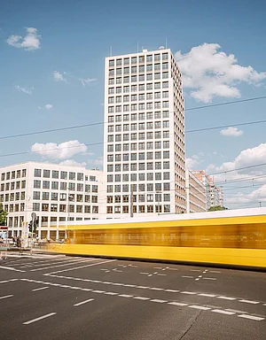 Blick auf die Zentrale der HOWOGE (Turm), davor eine Kreuzung mit Straßenbahn