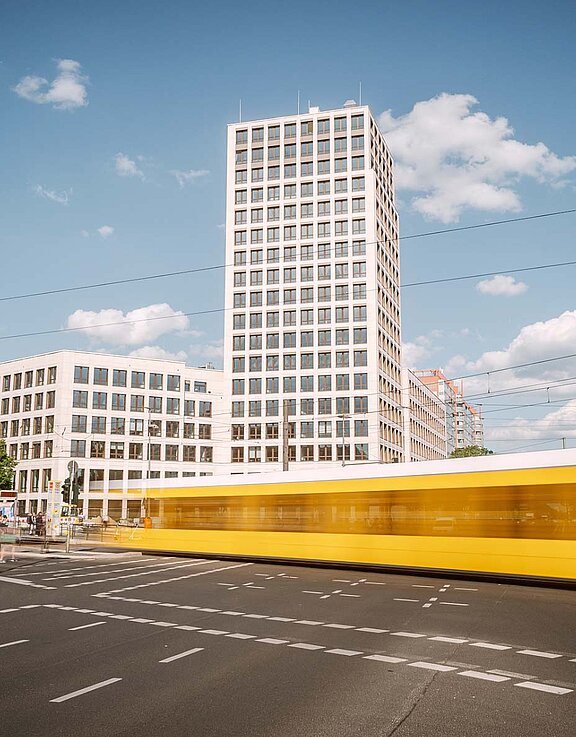 Blick auf die Zentrale der HOWOGE (Turm), davor eine Kreuzung mit Straßenbahn