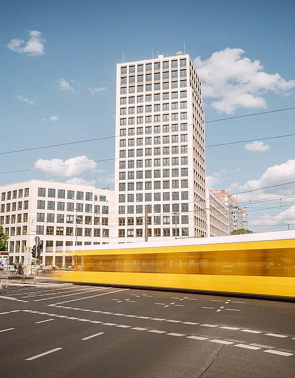 Blick auf die Zentrale der HOWOGE (Turm), davor eine Kreuzung mit Straßenbahn