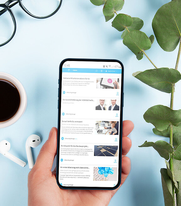 Hand mit einem Smartphone in der Hand. Darauf zu sehen ist eine App mit einer Liste an Themen.