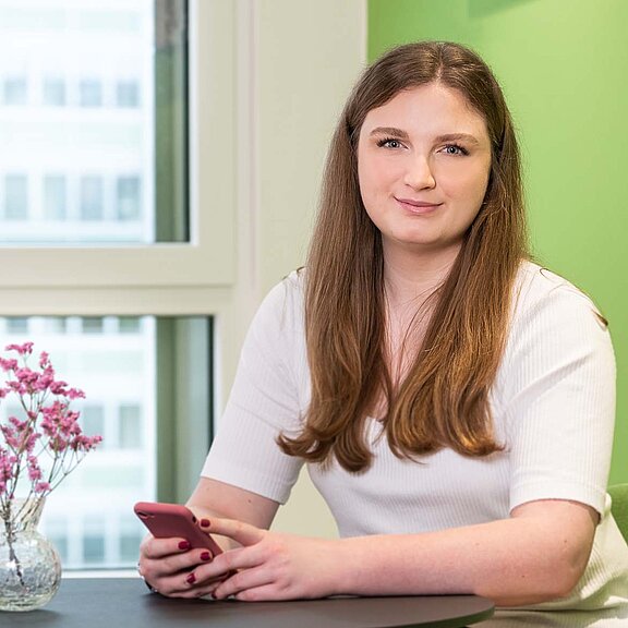 Junge Frau lacht in Kamera