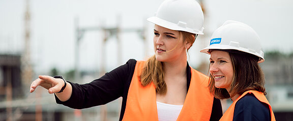 Zwei Frauen mit Bauhelm auf der Baustelle