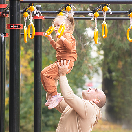 Vater mit Kind auf dem Spielplatz
